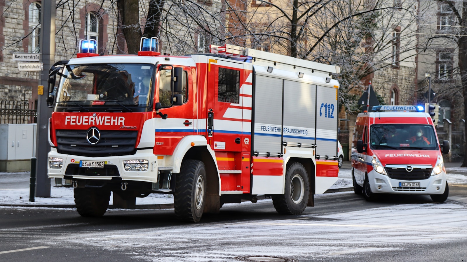 a red and white fire truck driving down a street