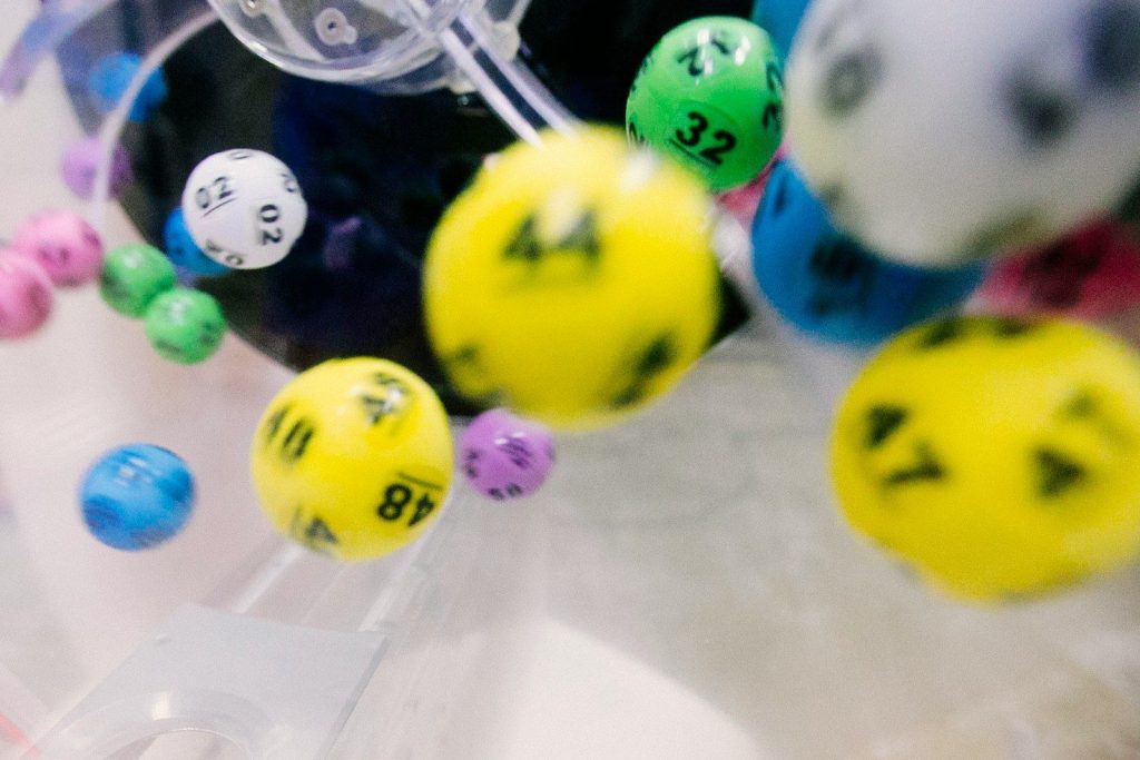 Colorful numbered lottery balls tumbling inside a clear plastic mixing machine