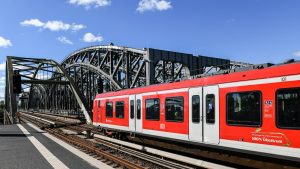 A red and white train traveling over a bridge