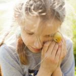 woman in gray long sleeve shirt holding yellow fruit