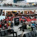 A large group of people sitting in an airport