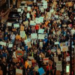 Crowd of people holding signs at a protest